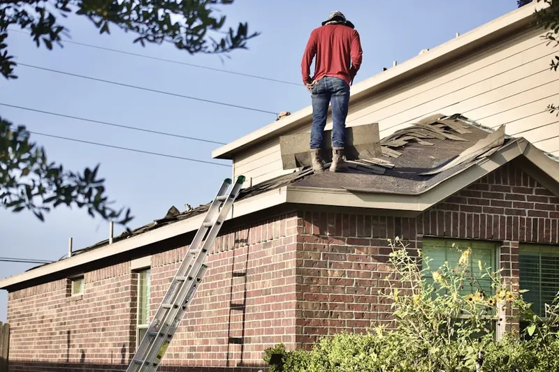 Professional roofer working on a residential roof in Hill Afb